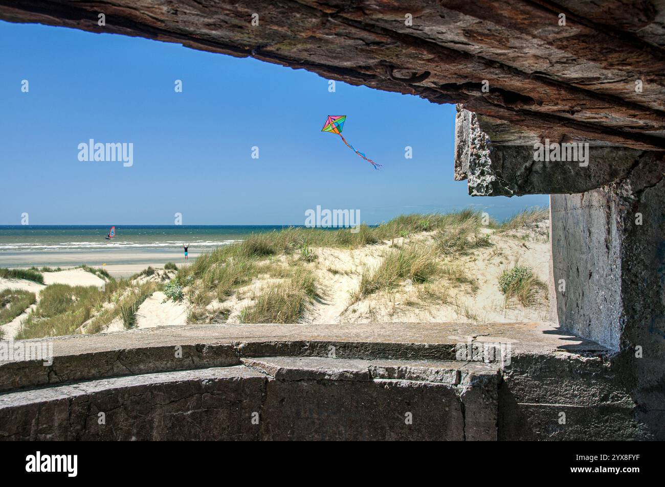 NACHKRIEGSSTRAND FRANKREICH DEUTSCHER 2. Weltkrieg BETONWAFFENEINBAU BUNKERGEWEHR FREIHEIT , mit Windsurfer und Drachenfliegen. Festung historische Nazikanone aus dem 2. Weltkrieg und Aussichtspunkt Bunker mit Blick auf die Strände von Fort-Mahon plage Nordfrankreich Stockfoto