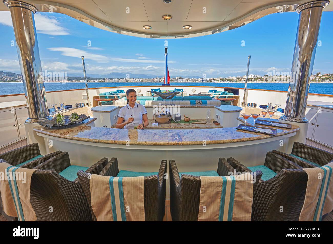 Eine moderne und elegante Bar im Freien auf einer luxuriösen Yacht mit Meerblick. Die Einrichtung verfügt über Granitablageflächen und stilvolle Sitzgelegenheiten. Stockfoto