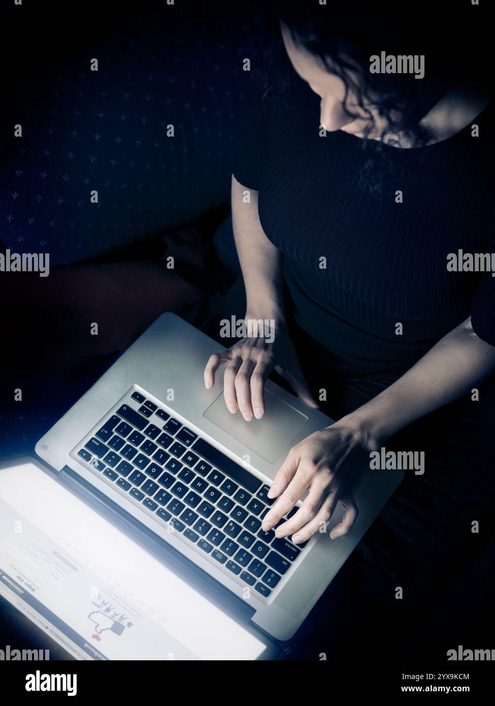 Frau mit einem Laptop-Computer zu Hause, Draufsicht, Facebook-Login-Seite auf dem display Stockfoto