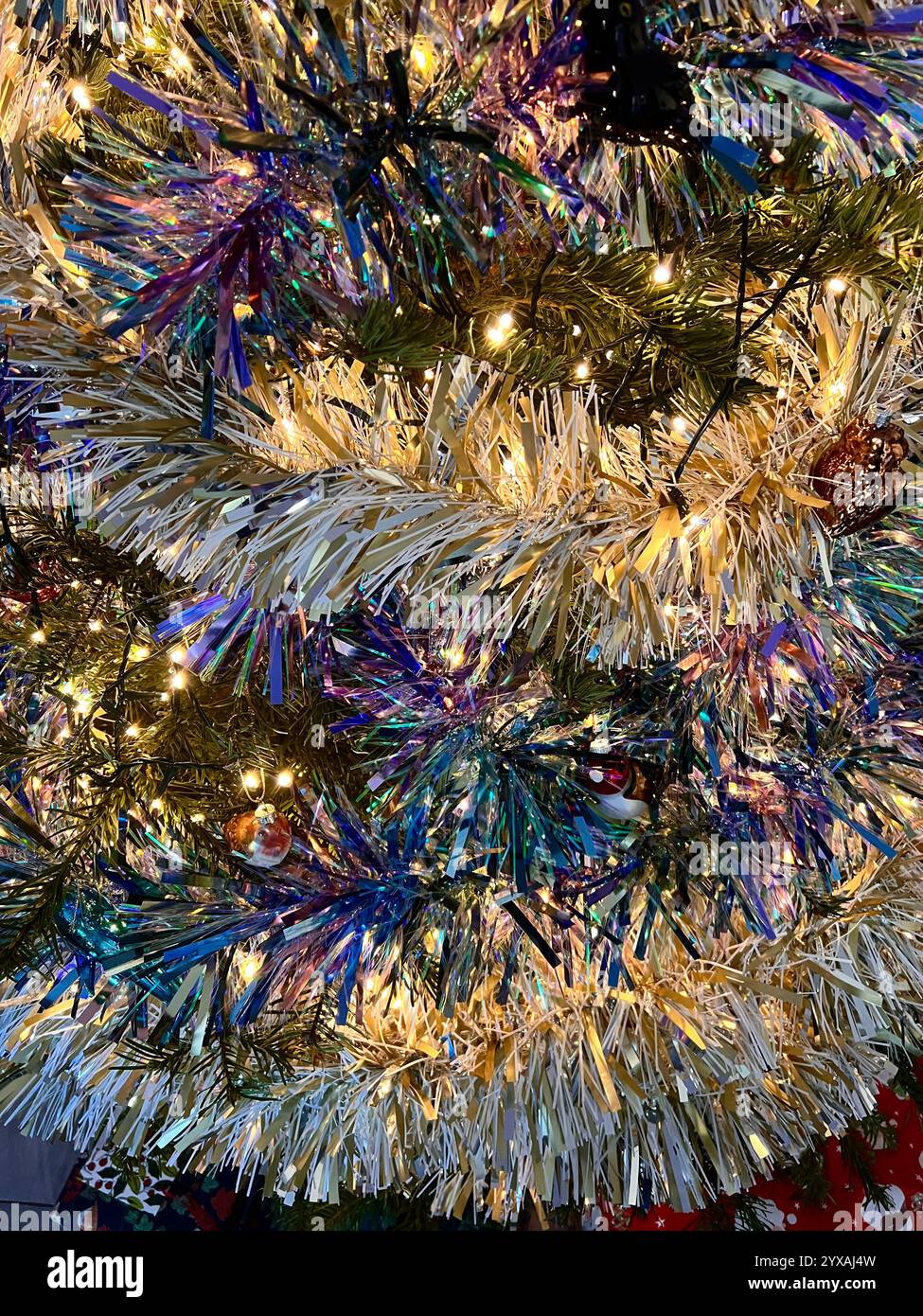 Weihnachtsbaum mit glitzerndem Lametta. Nahaufnahme. - Smartphone-aufgenommenes Stockfoto