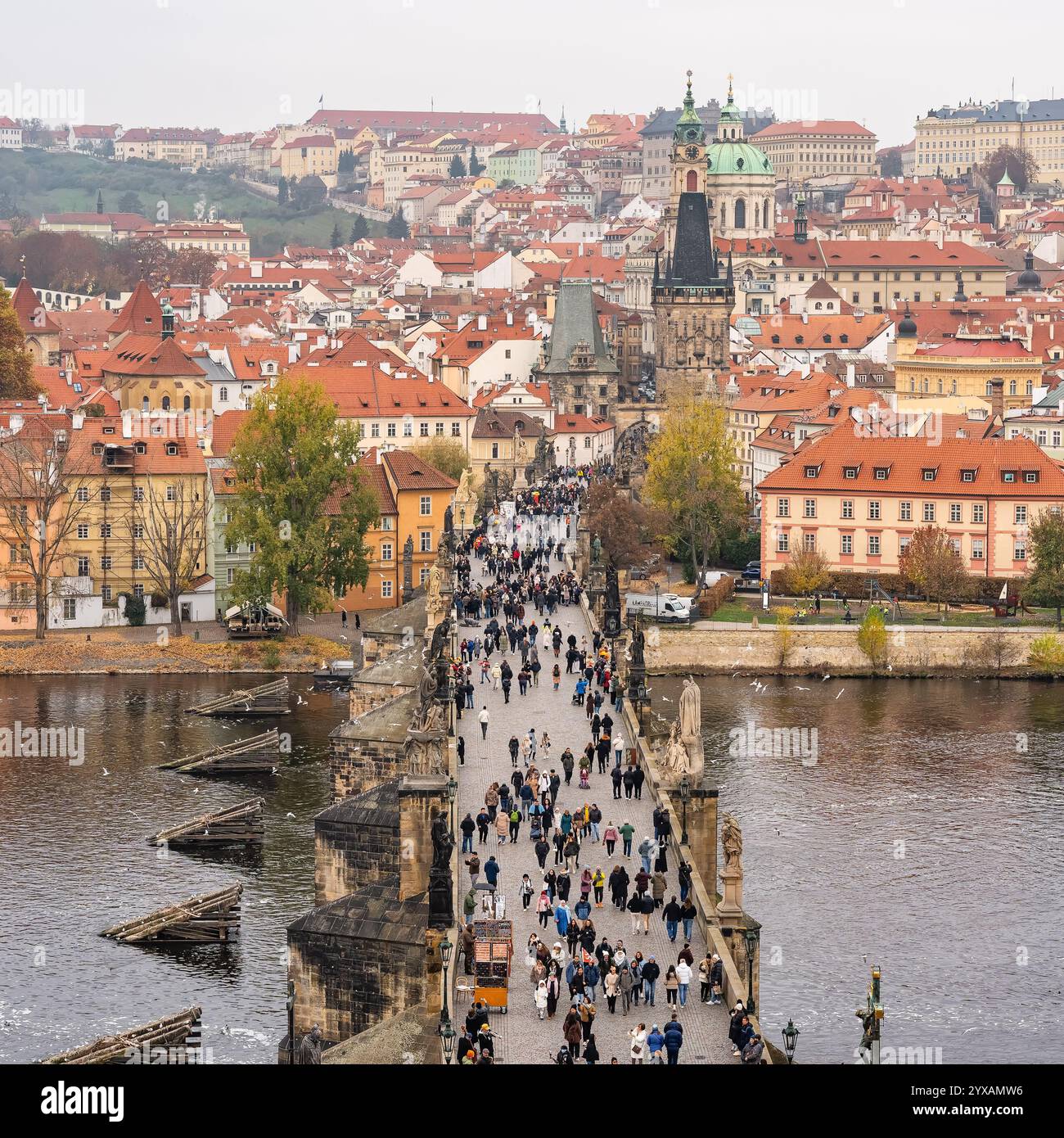 Prag, Tschechische Republik, 12. November 2024: Karlsbrücke überfüllt mit Touristen, die Prags älteste Brücke überqueren. Stockfoto