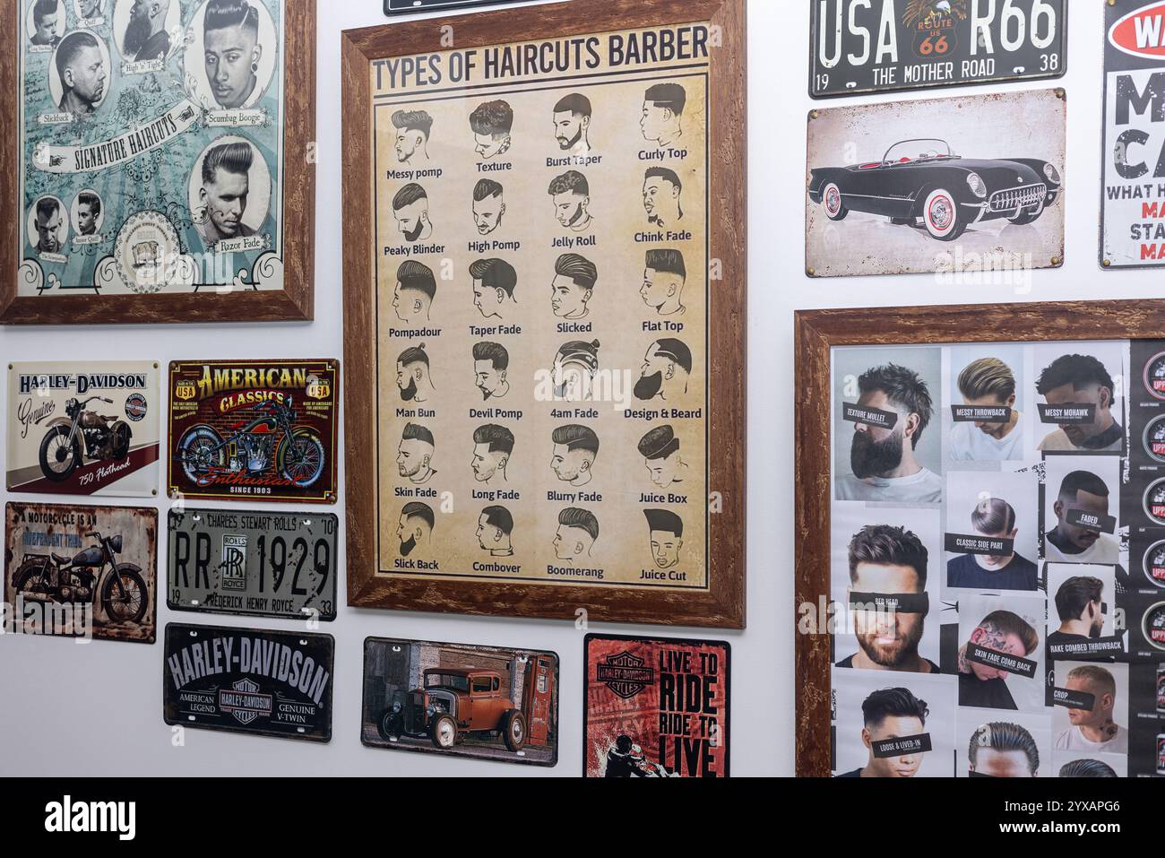 Eine Wand im Friseurladen mit gerahmten Friseurkarten, Vintage-Schildern und Retro-Kunstwerken schafft eine nostalgische und stilvolle Einrichtung. Stockfoto