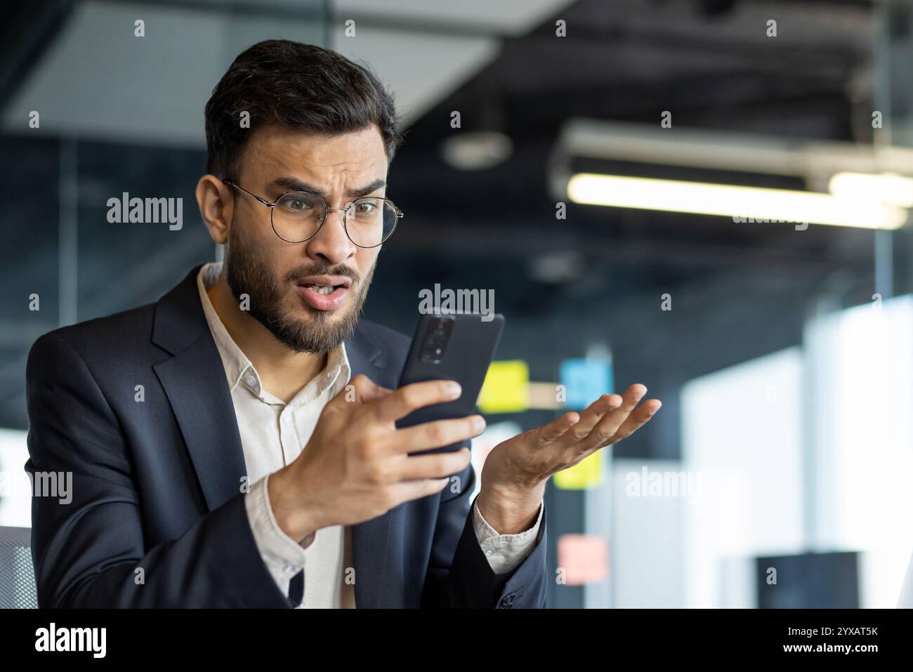 Reife Mann Geschäftsmann Gesten emotional Hone im Amt halten . Der Gesichtsausdruck und die Handbewegung der Person bedeuten überraschende oder frustrierte Reaktionen, unerwartete Nachrichten oder Kommunikation Stockfoto