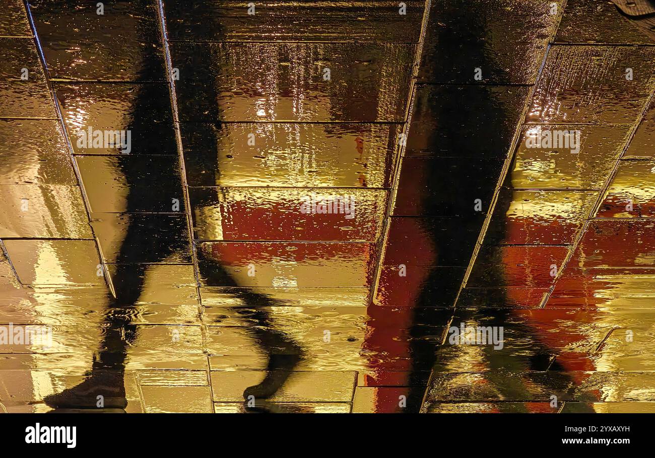 Folgen Sie mir: Schatten auf einem regnerischen Spaziergang Stockfoto