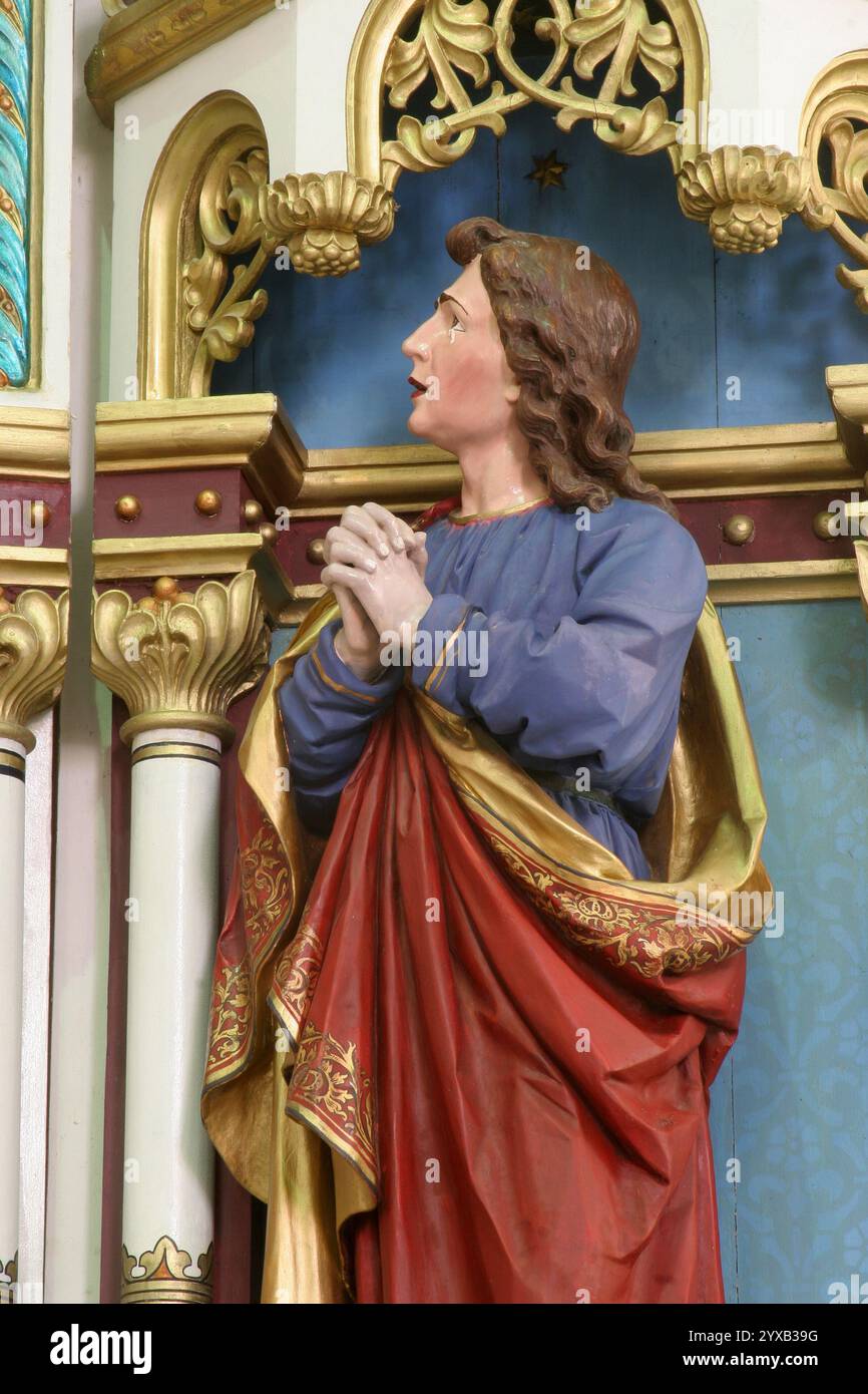Johannes unter dem Kreuz, Statue auf dem Altar des Heiligen Kreuzes in der Pfarrkirche der Heiligen Dreifaltigkeit in Trojstvo, Kroatien Stockfoto
