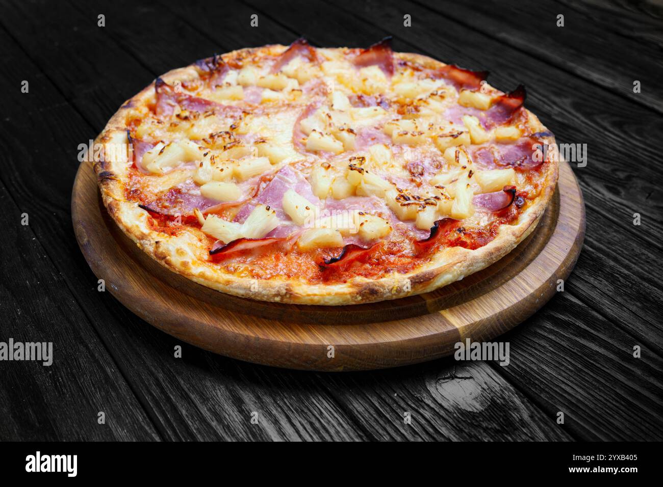 Köstliche italienische Pizza, hawaiianisch, Nahaufnahme auf dunklem Holztisch, rustikaler Stil Stockfoto