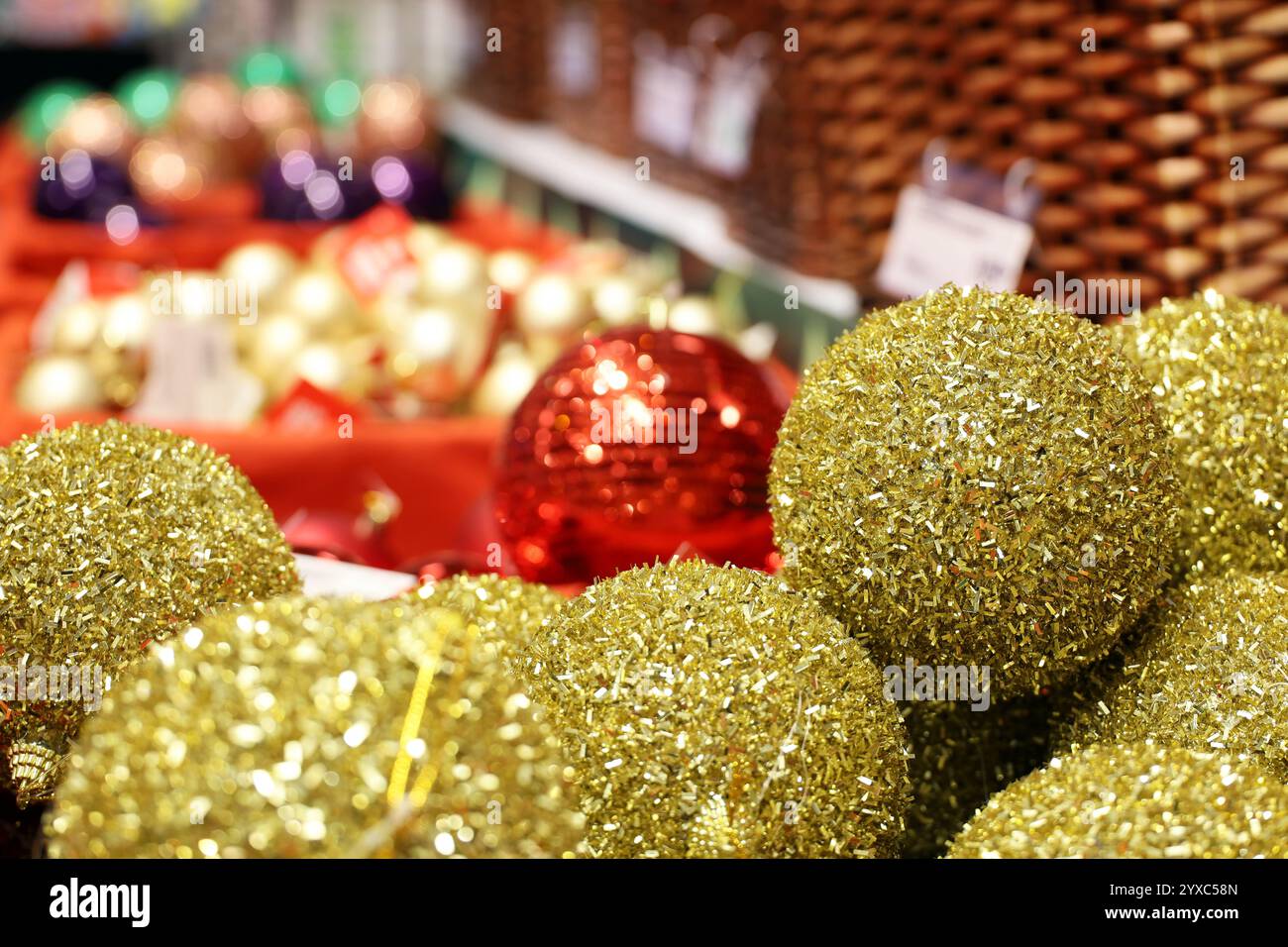 Weihnachtsspielzeug, goldene Kugeln im Korb auf festlichem Hintergrund. Neujahrsdekoration in einem Laden Stockfoto
