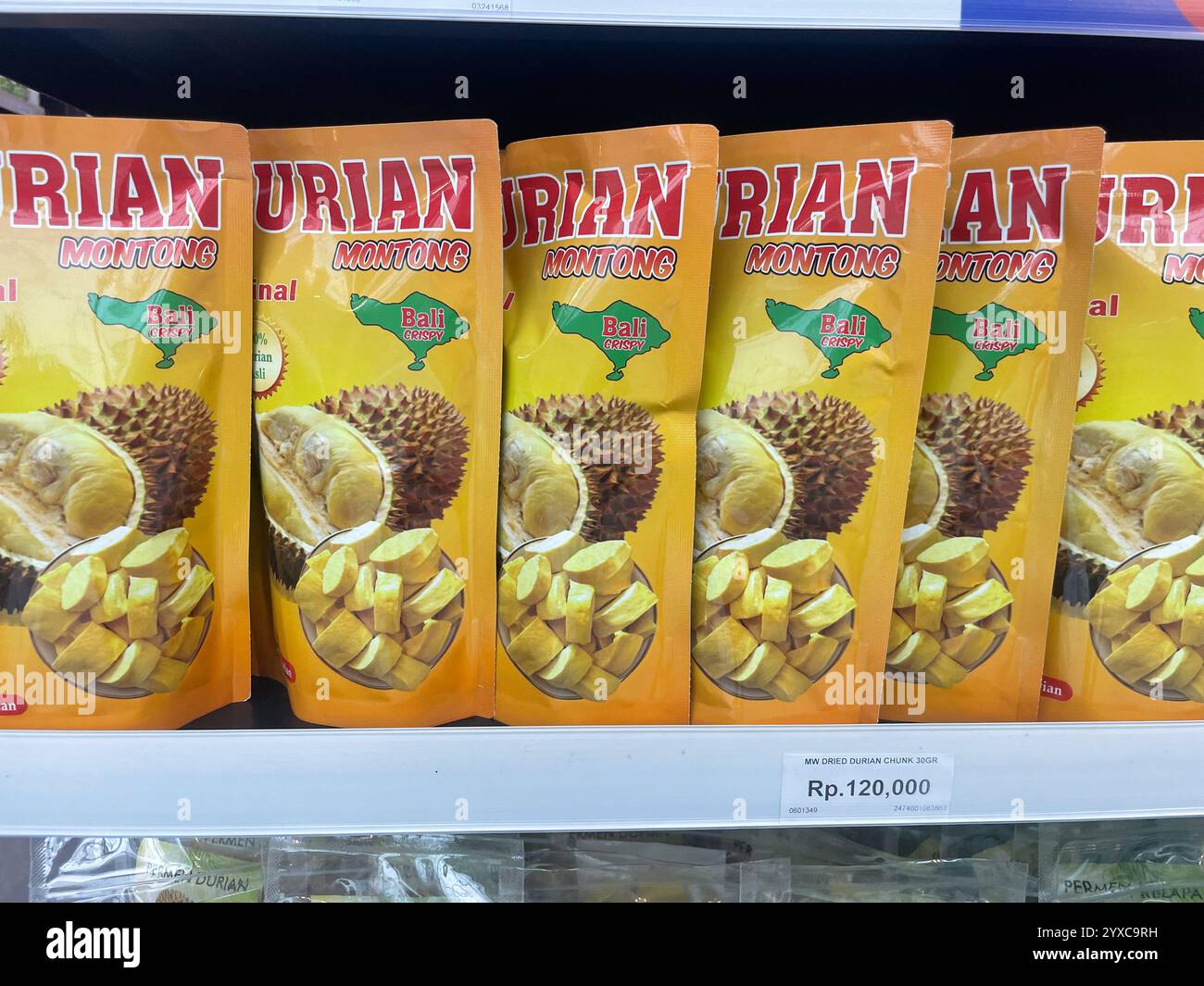Packungen getrockneter Durian-Stücke mit der Aufschrift „Durian Montong“ mit „Bali Crispy“-Branding und Preisgestaltung sichtbar, Jakarta Airport, Indonesien - Smartphone-aufgenommenes Stockfoto
