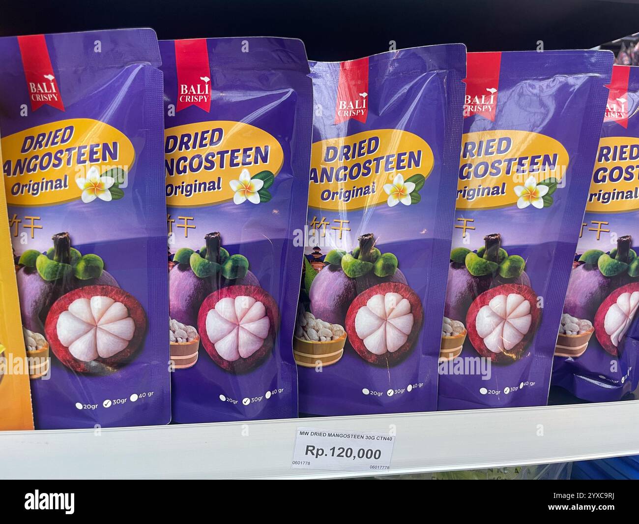 Packungen von getrocknetem Mangostan mit der Aufschrift 'getrocknete Mangostan Original' mit 'Bali Crispy' Branding und Preisschild, Jakarta Airport, Indonesien - Smartphone-aufgenommenes Stockfoto