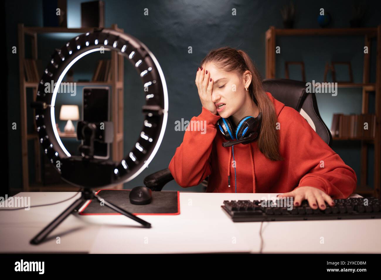 Verärgerte Gamer-Streamingerin frustriert über Probleme, Streams oder Liveübertragungen mit Ringlicht zu führen, die nachts im Zimmer sitzen und schlechte Laune verdecken Stockfoto