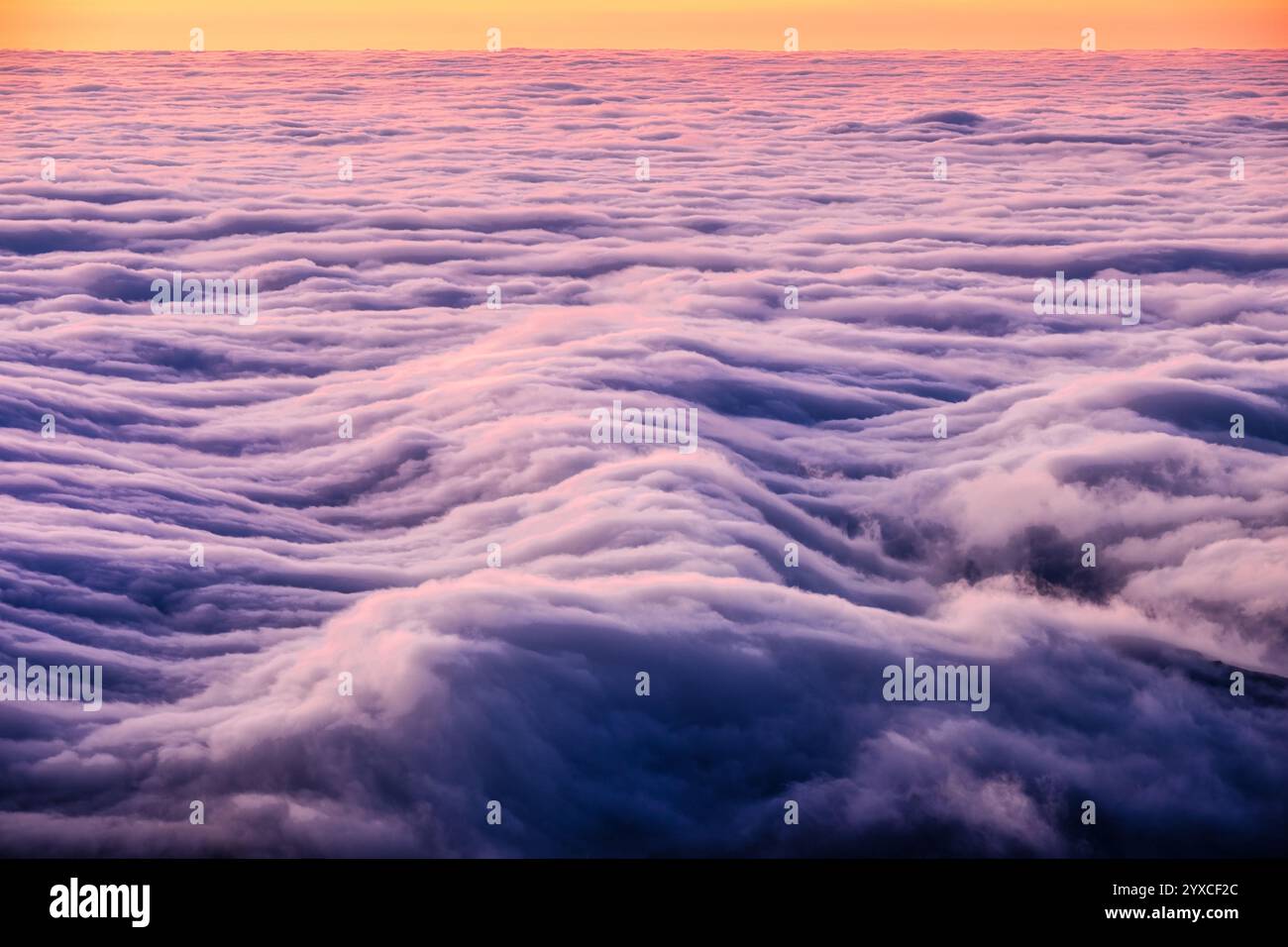 Farbenfroher lebendiger Sonnenaufgangshimmel mit dramatischen Wolkenwellen auf den Azoren Stockfoto