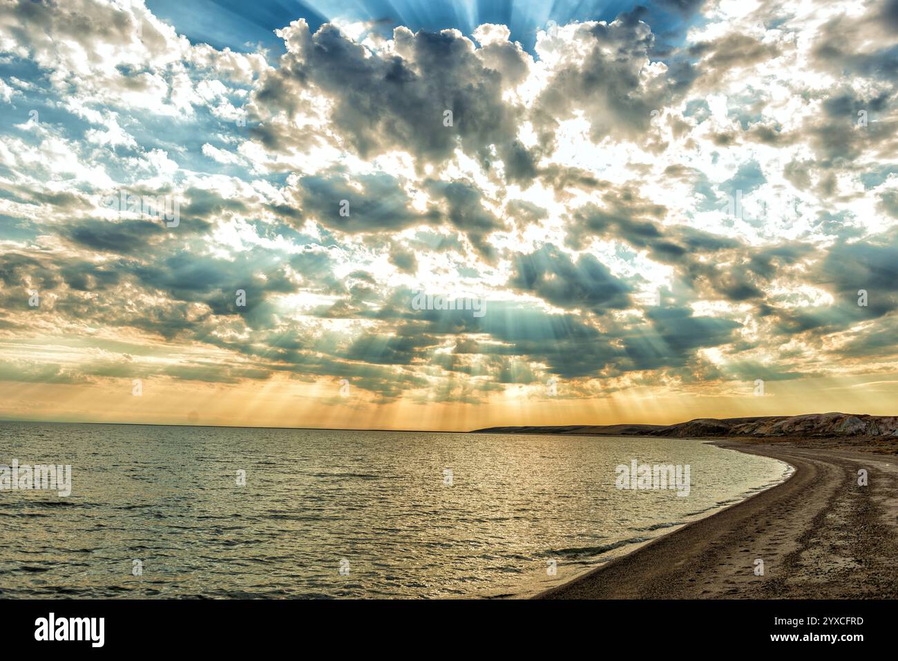 Die Sonnenstrahlen brechen durch die Wolken auf die Oberfläche des Sees Stockfoto