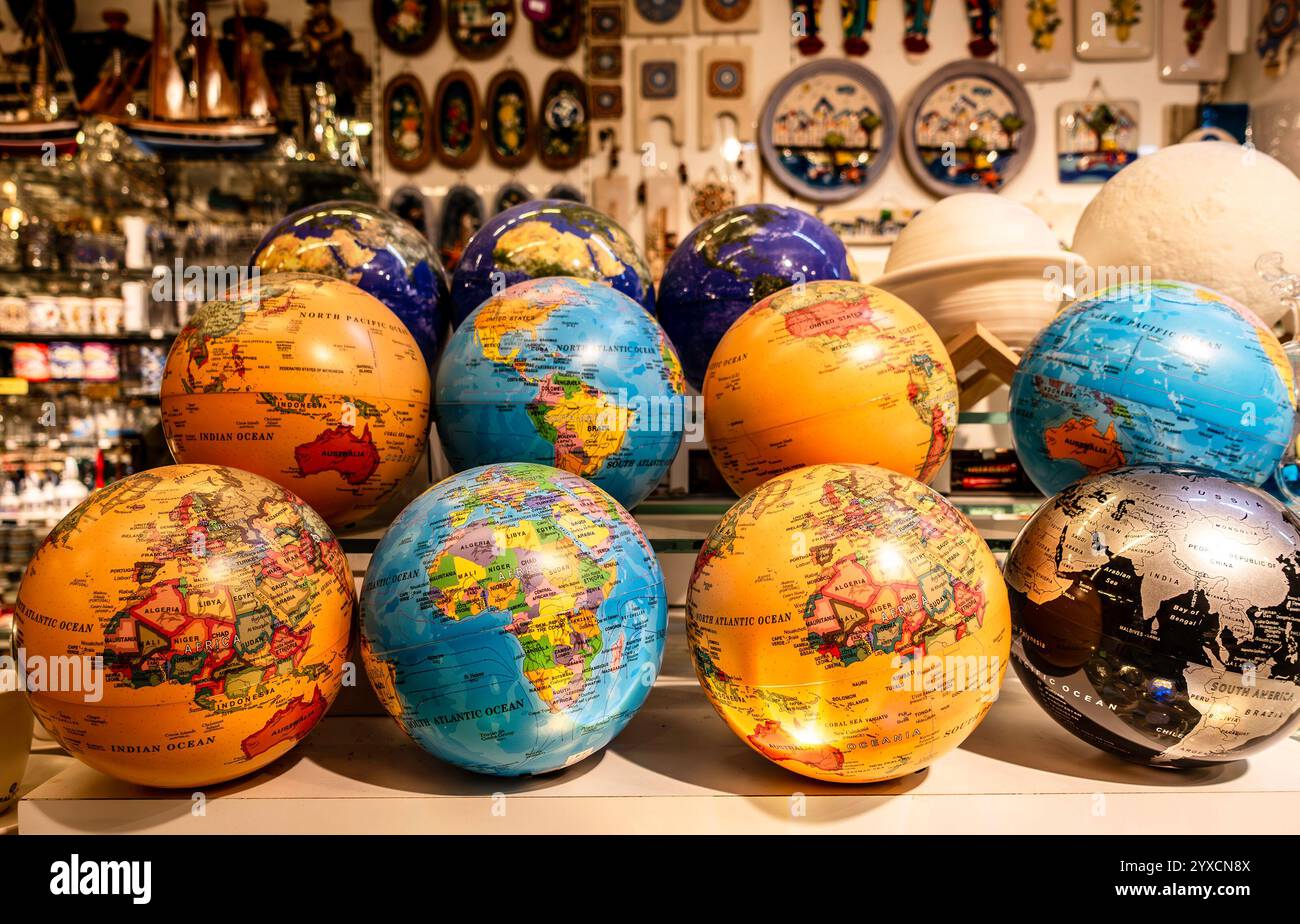 Farbenfrohe Globen mit detaillierten Weltkarten in einer ansprechenden Ausstellung, die geografische Besonderheiten und den Bildungswert in Bodrum, Turkiye, hervorheben Stockfoto