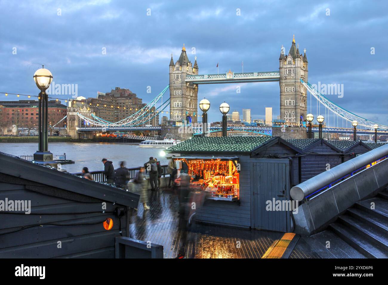 London Tower Bridge, die bei Sonnenuntergang über dem Weihnachtsmarkt am Fluss in Großbritannien thront. Stockfoto