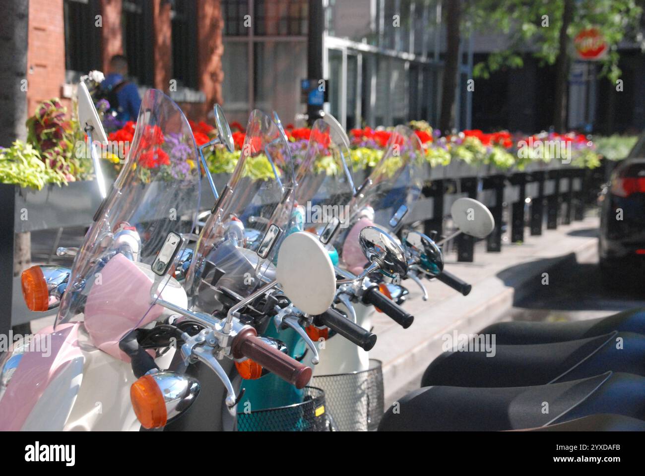 Eine Reihe von bunten Motorrädern parkt hintereinander, vor einem Restaurant. Stockfoto