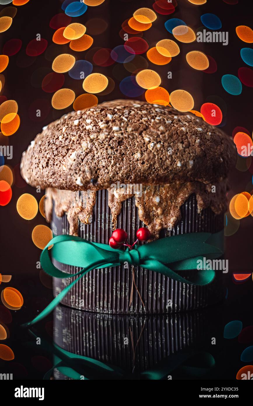 Italienischer Weihnachtskuchen Panettone, weiches traditionelles süßes Brot mit Nüssen, Rosinen und Schokolade gegen Retro-Bokeh-weihnachtsbeleuchtung Stockfoto