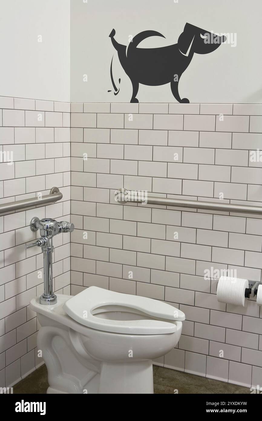 Humorvolle Zeichentrickzeichnung eines Hundes, der sein Bein an der Wand eines kommerziellen Badezimmers hebt Stockfoto