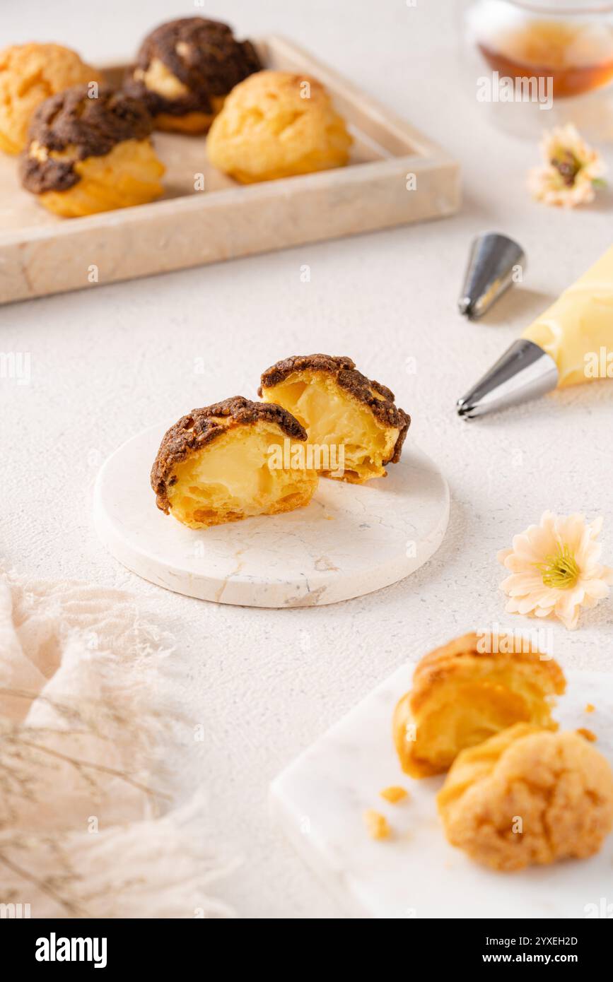 Choux-Gebäck ist ein zarter Teig, der in vielen Backwaren verwendet wird. Es enthält nur Butter, Wasser, Mehl und Eier. Choux-Gebäck wird manchmal gefüllt Stockfoto