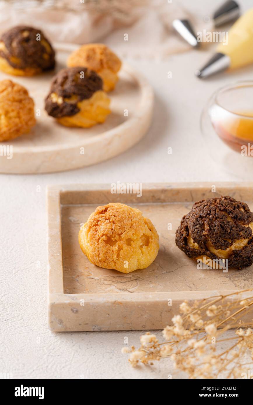 Choux-Gebäck ist ein zarter Teig, der in vielen Backwaren verwendet wird. Es enthält nur Butter, Wasser, Mehl und Eier. Choux-Gebäck wird manchmal gefüllt Stockfoto