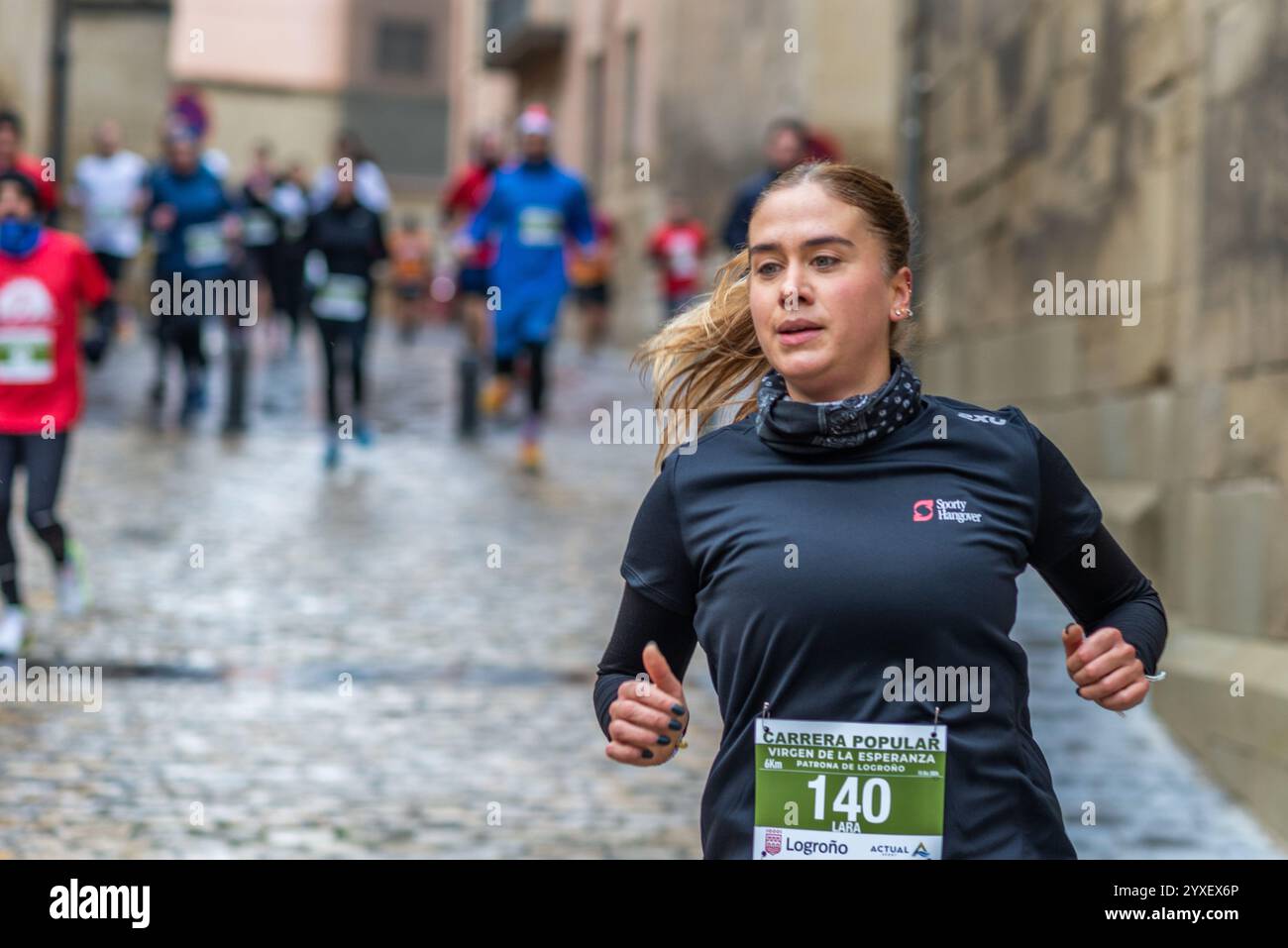 Logrono, La Rioja, Spanien. 15. Dezember 2024. Die beliebte Virgen de la Esperanza in Carrera ist ein emblematisches Sportereignis in Logrono, bei dem mehr als 300 Läufer 6 Kilometer durch die malerische Altstadt laufen. Teilnehmer verschiedener Altersstufen und Niveaus laufen durch historische Straßen und nutzen das städtische Layout mit seiner reichen mittelalterlichen Architektur. Das Rennen ist nicht nur ein Sportereignis, sondern auch eine kulturelle Feier zu Ehren des Schutzpatrons der Stadt. Quelle: MARIO MARTIJA/Alamy Live News Stockfoto