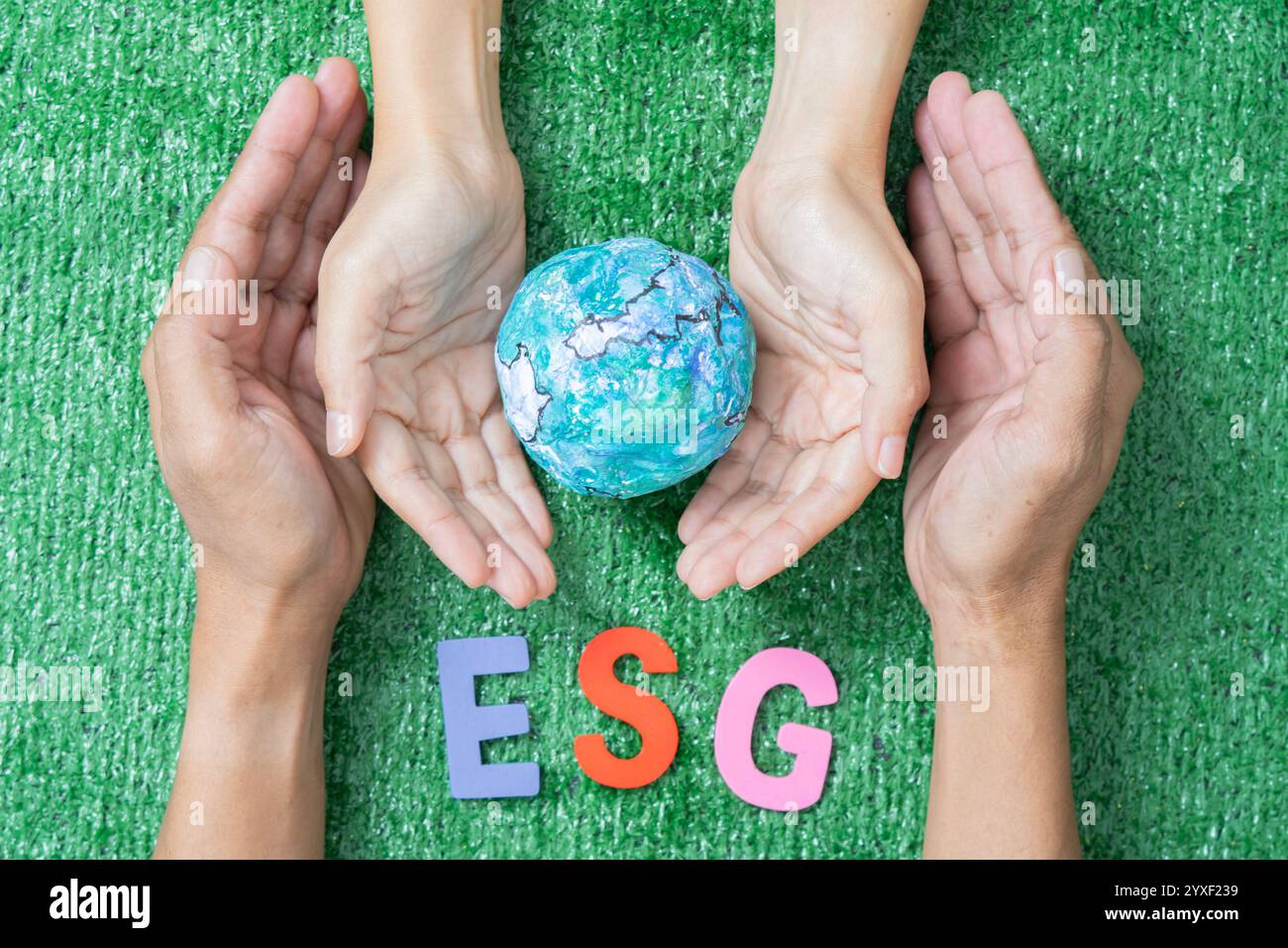 Konzeptuelles Symbol multirassischer menschlicher Hände, die den Erdball umgeben. ESG-Konzept. Stockfoto