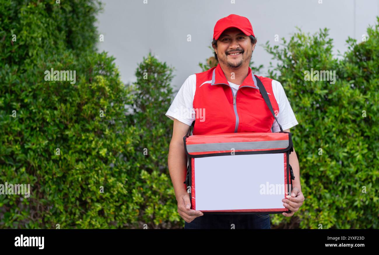 Liefermann mit rotem Thermobeutel. Schnelle und bequeme Lieferung von Lebensmitteln während einer Epidemie von Viruserkrankungen. Mann, der Lebensmittel an Kunden liefert. Stockfoto