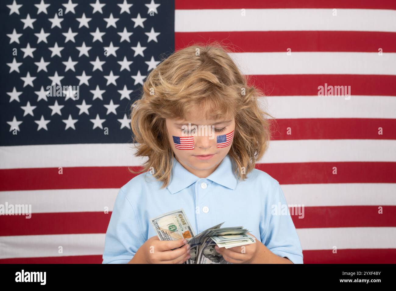 American Dollars Geldscheine Konzept. Der Junge hat eine Menge von hundert Dollar isoliert auf Studiohintergrund. Kind mit amerikanischer Flagge. Stockfoto