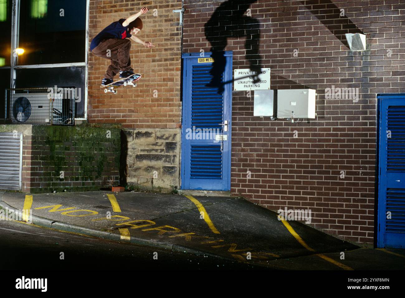 Skateboarder springt von Brick Wall Stockfoto