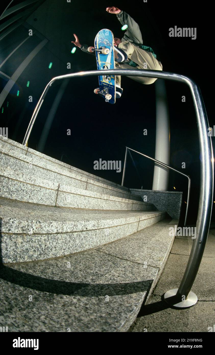 Skateboarder Balancierung auf Metallgeländer (Weitwinkel) Stockfoto