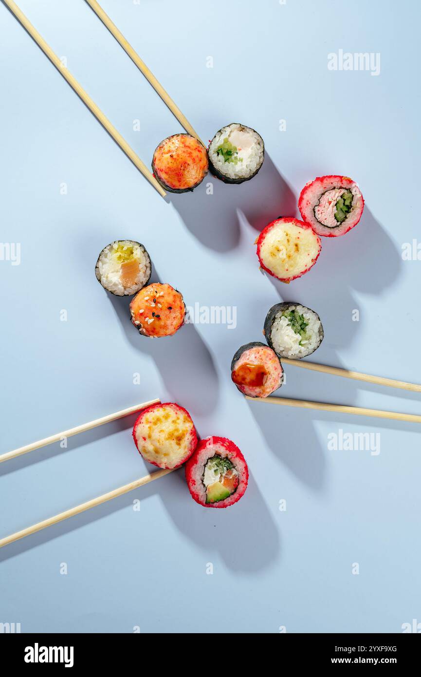 Stilvolle Präsentation von Sushi-Brötchen mit chinesischen Essstäbchen Stockfoto