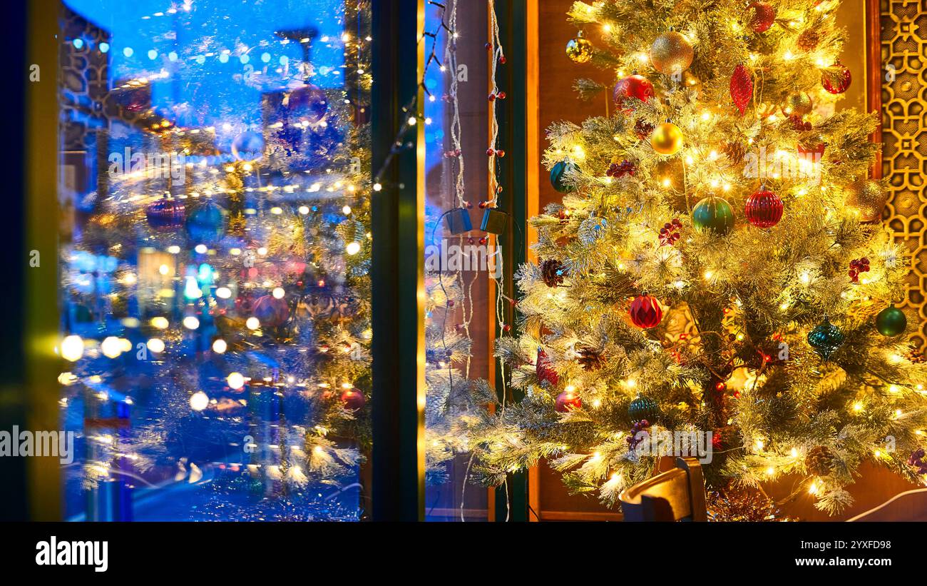 Blaue Winterstraße und warmer Weihnachtsbaum Stockfoto