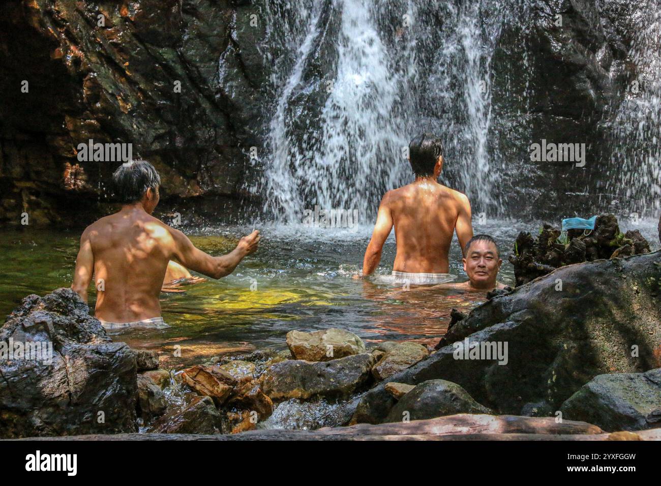 Phu Quoc, Vietnam. Dez 15.2024: Vor dem Ansturm des Übertourismus suchen die einheimischen Inselbewohner Zuflucht in die Kühle der Waldwasserfälle, fernab von übertouristischen Stränden und brandneuen Resorts. Die Paradies-Insel, deren Nationalpark 2006 zum UNESCO-Biosphärenreservat erklärt wurde, wurde in den letzten Jahren von Konglomeraten wie Sun Group & Vingroup in eine Inselstadt oder ein vietnamesisches Phuket mit 40.000 Hotelzimmern umgebaut. Die Insel, die vor 20 Jahren nur 130.000 Touristen willkommen hieß, erwartet in diesem Jahr 6 Millionen. Quelle: Kevin Izorce/Alamy Live News Stockfoto