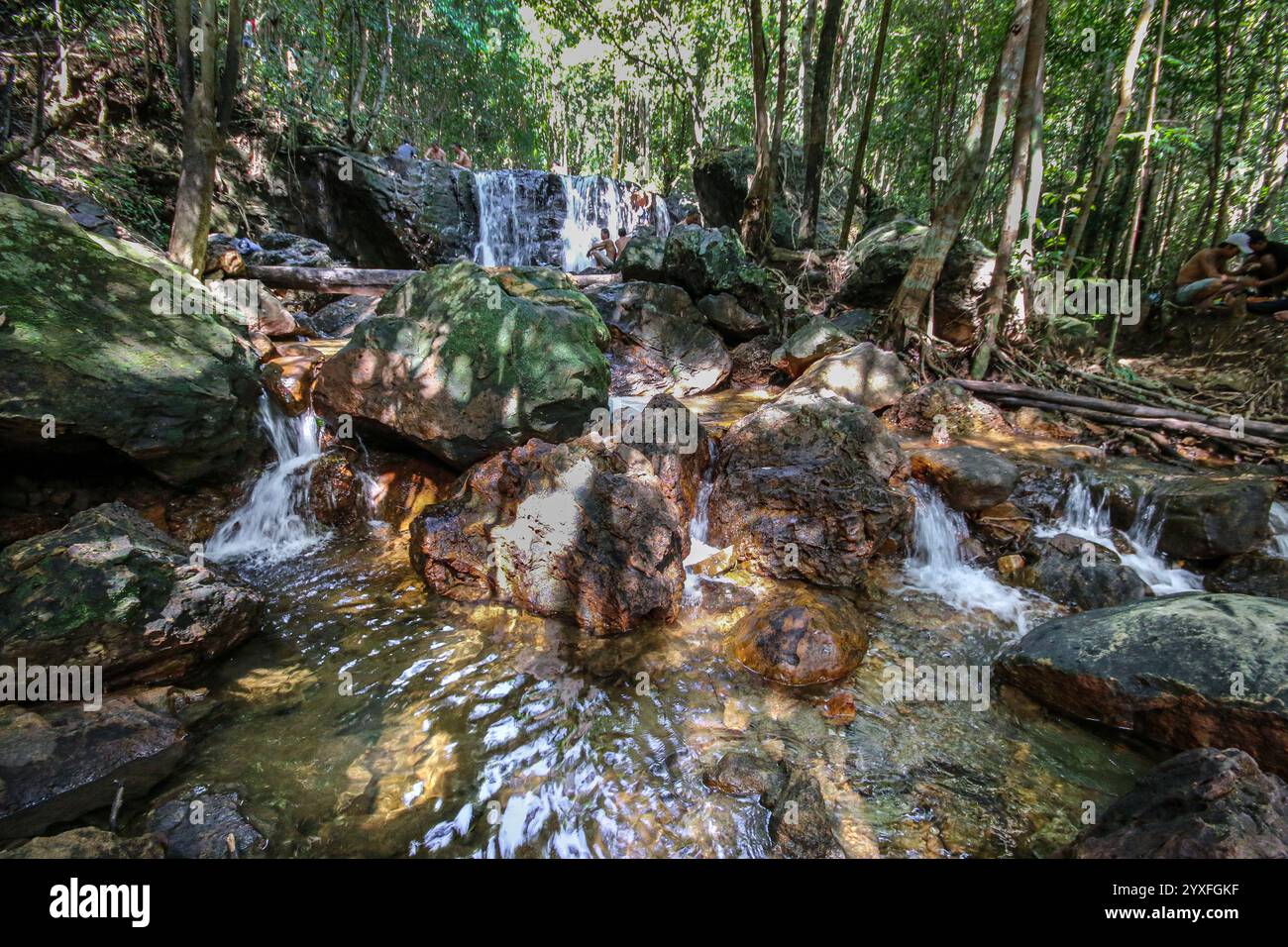 Phu Quoc, Vietnam. Dez 15.2024: Vor dem Ansturm des Übertourismus suchen die einheimischen Inselbewohner Zuflucht in die Kühle der Waldwasserfälle, fernab von übertouristischen Stränden und brandneuen Resorts. Die Paradies-Insel, deren Nationalpark 2006 zum UNESCO-Biosphärenreservat erklärt wurde, wurde in den letzten Jahren von Konglomeraten wie Sun Group & Vingroup in eine Inselstadt oder ein vietnamesisches Phuket mit 40.000 Hotelzimmern umgebaut. Die Insel, die vor 20 Jahren nur 130.000 Touristen willkommen hieß, erwartet in diesem Jahr 6 Millionen. Quelle: Kevin Izorce/Alamy Live News Stockfoto