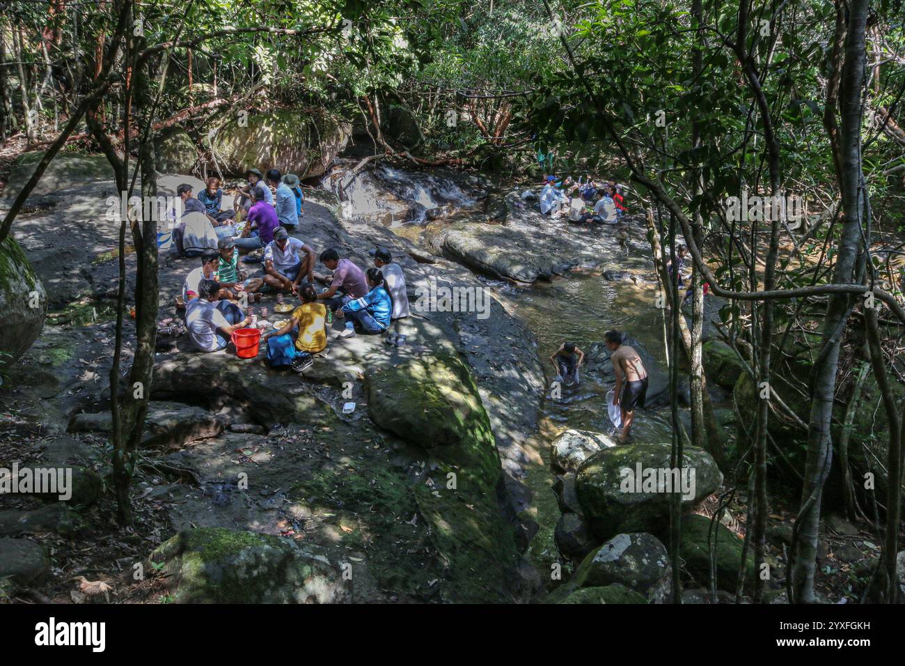 Phu Quoc, Vietnam. Dez 15.2024: Vor dem Ansturm des Übertourismus suchen die einheimischen Inselbewohner Zuflucht in die Kühle der Waldwasserfälle, fernab von übertouristischen Stränden und brandneuen Resorts. Die Paradies-Insel, deren Nationalpark 2006 zum UNESCO-Biosphärenreservat erklärt wurde, wurde in den letzten Jahren von Konglomeraten wie Sun Group & Vingroup in eine Inselstadt oder ein vietnamesisches Phuket mit 40.000 Hotelzimmern umgebaut. Die Insel, die vor 20 Jahren nur 130.000 Touristen willkommen hieß, erwartet in diesem Jahr 6 Millionen. Quelle: Kevin Izorce/Alamy Live News Stockfoto