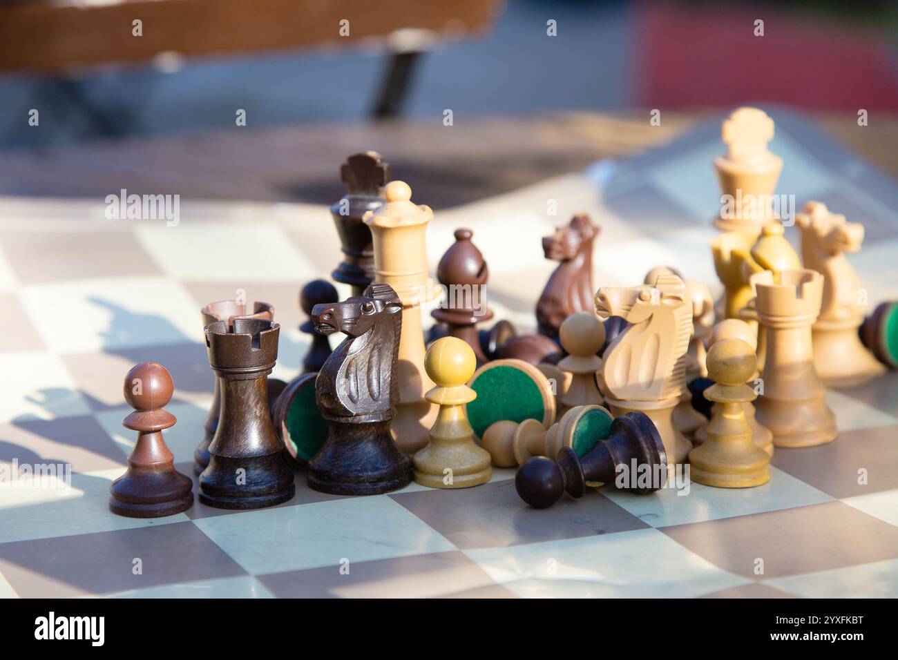 Eine Sammlung aufwändig gestalteter hölzerner Schachfiguren, die auf einem Schachbrett platziert werden Stockfoto