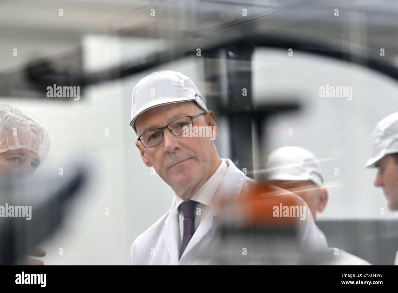 Der erste schottische Minister John Swinney betrachtet Maschinen während einer Tour durch die Fabrik des Centre for Process Innovation (CPI) während eines Besuchs zur Spatenstichzeremonie des Oligonukleotid Manufacturing Innovation Centre of Excellence im Medicines Manufacturing Innovation Centre in Paisley, Glasgow. Oligonukleotid-Therapien und -Arzneimittel haben das Potenzial, Behandlungen für Krankheiten wie Krebs, Herzerkrankungen und Alzheimer-Krankheit anzubieten. Bilddatum: Montag, 16. Dezember 2024. Stockfoto