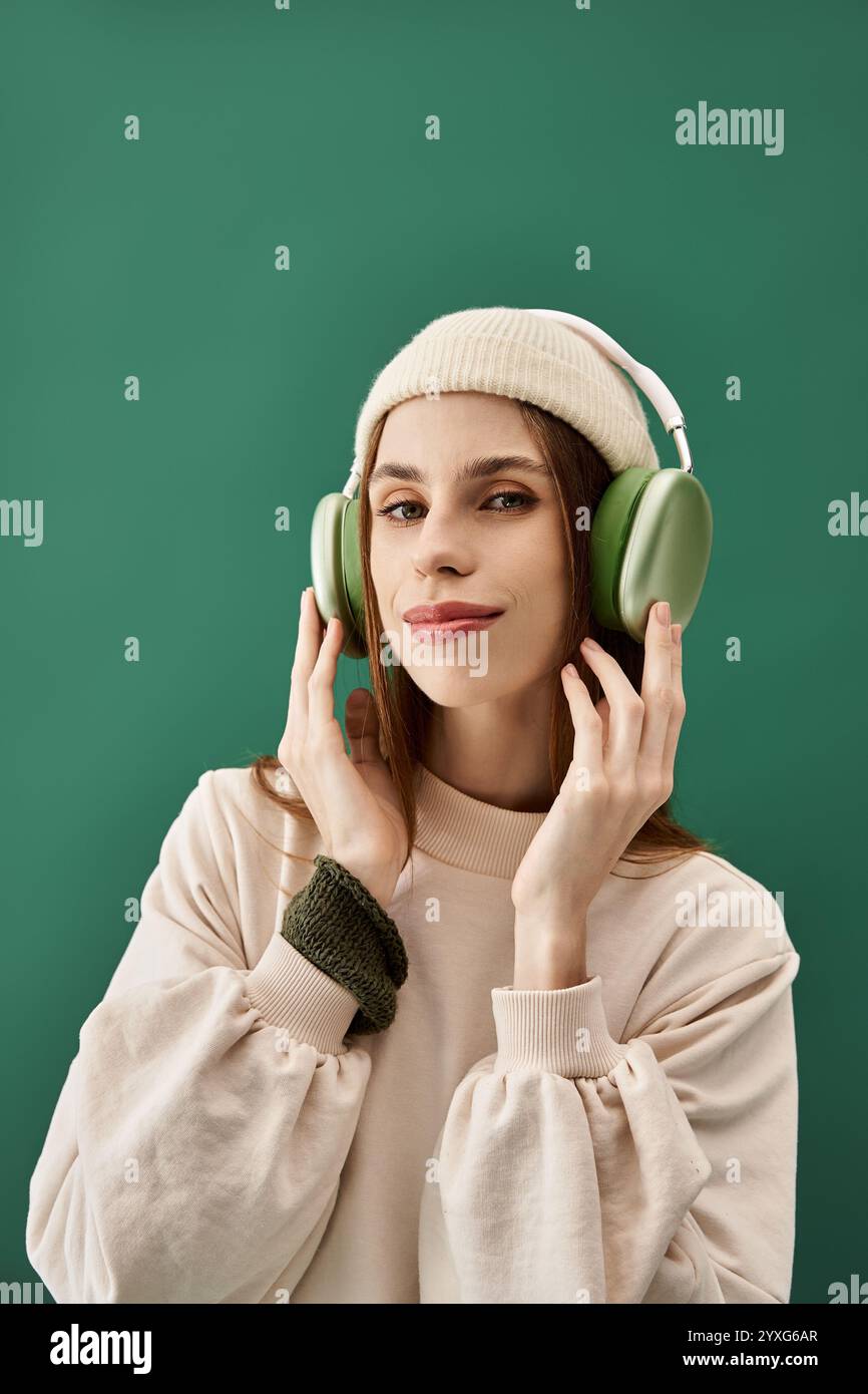 Eine junge Frau genießt Musik, während sie Kopfhörer trägt und zeigt ihren einzigartigen Stil und ihr Selbstvertrauen. Stockfoto