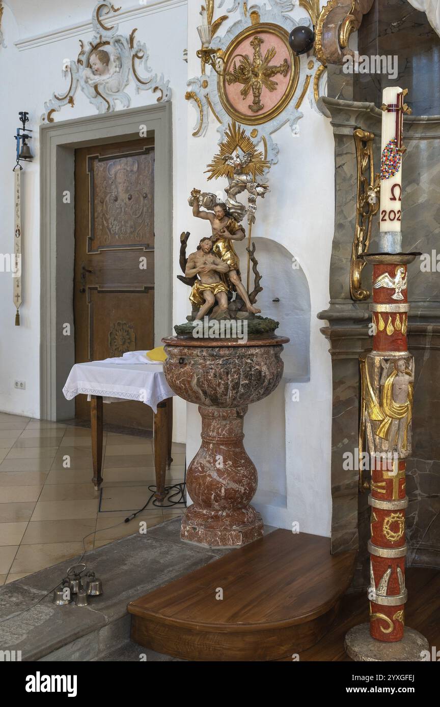 Taufbecken und Osterkerze in der Rokoko-Kirche St. Ulrich, liebevoll bekannt als -die kleine Wiese-, Seeg, Allgäu, Bayern, Deutschland, Euro Stockfoto