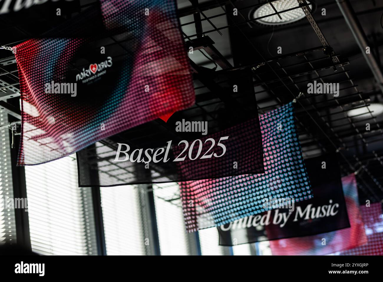 Basel, Schweiz. Dezember 2024. Flaggen mit dem offiziellen Design des Eurovision Song Contest (ESC) 2025 hängen in einem Basler Club. Die Organisatoren des Eurovision Song Contests 2025 in Basel präsentieren heute das Design und die Bühnengestaltung des ESC 2025 und geben Einblicke in Bereiche wie Ticketing und Sponsoring. Quelle: Philipp von Ditfurth/dpa/Alamy Live News Stockfoto