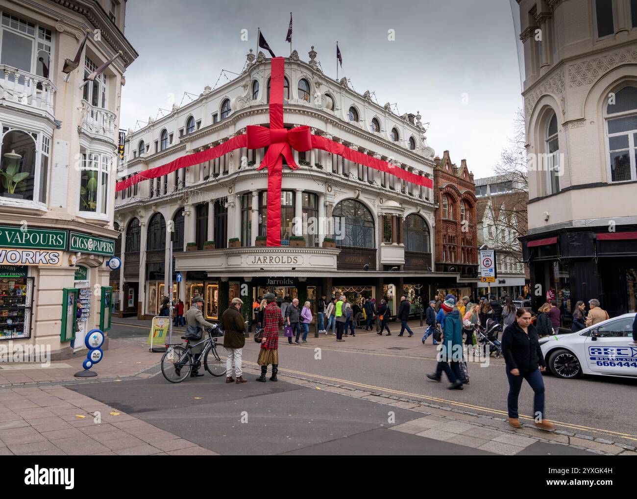 Jarrolds Norwich Ladenfront mit großem rotem weihnachtsband vor dem Gebäude mit Käufern vor dem Gebäude. Stockfoto