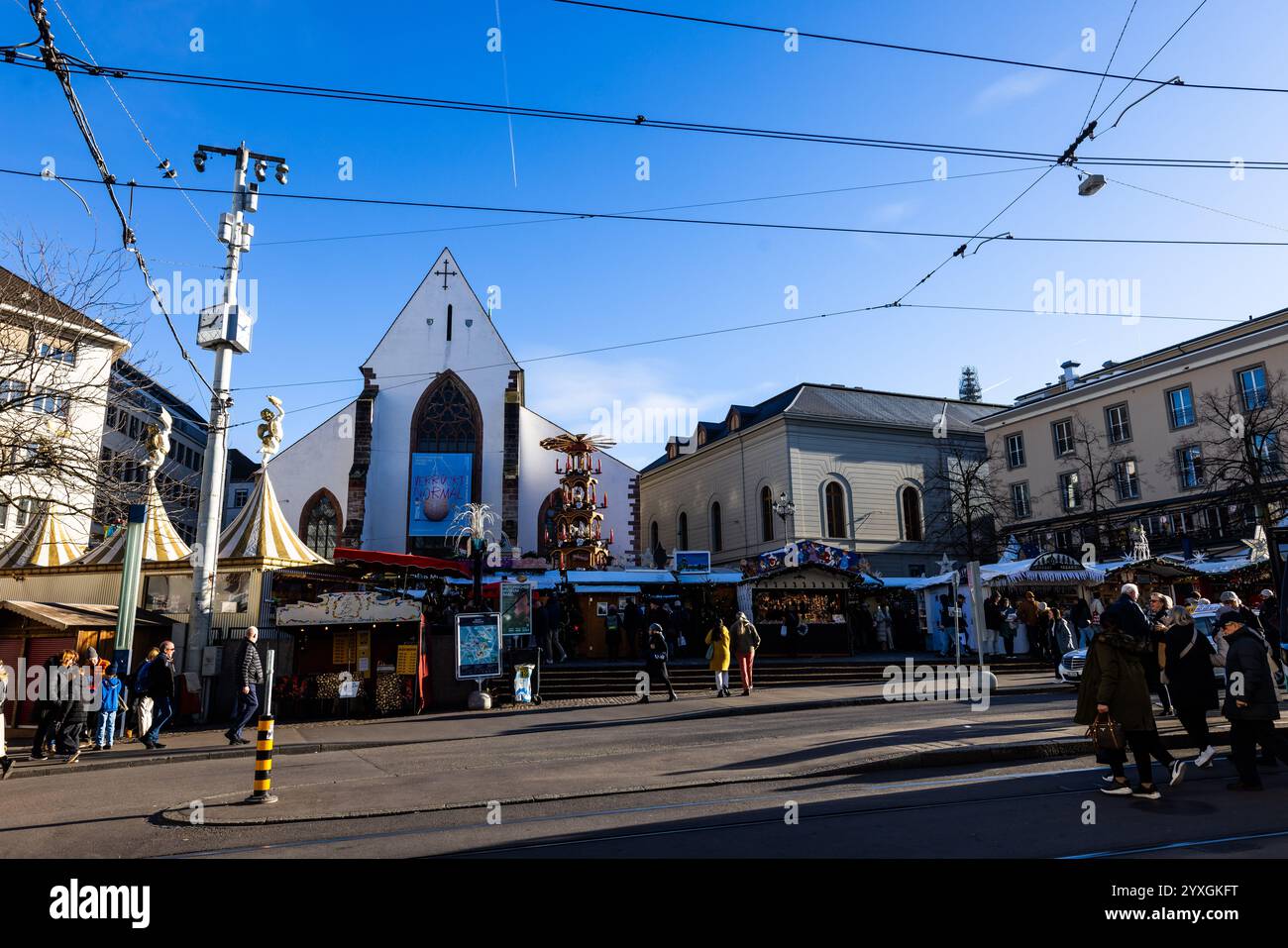 Basel, Schweiz. Dezember 2024. Die Menschen laufen über den Barfüsserplatz in Basel. Die Organisatoren des Eurovision Song Contest (ESC) 2025 in Basel präsentieren heute das Design und die Bühnengestaltung des ESC 2025 und geben Einblicke in Bereiche wie Ticketing und Sponsoring. Quelle: Philipp von Ditfurth/dpa/Alamy Live News Stockfoto