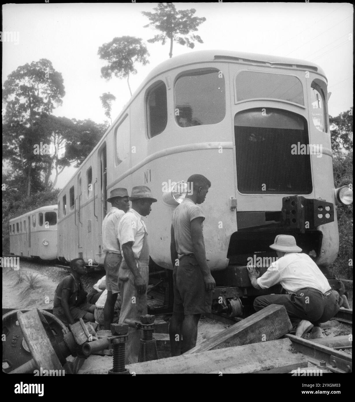 Belgien Kongo, Thysville (Mbanza Ngungu): Eisenbahnstrecke; Ein entgleister Zug ohne Vorderachse steht auf einer provisorischen Stütze auf den Gleisen, umgeben von mehreren Arbeitern. Archivfoto von Annemarie Schwarzenbach, von Reisen in der Demokratischen Republik Kongo (DRK), dann Belgischen Kongo, um 1940 Stockfoto