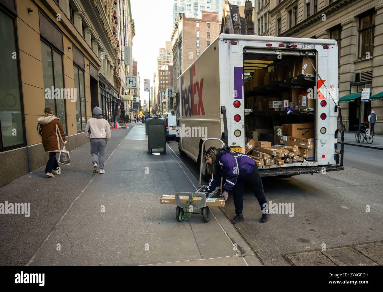FedEx-Mitarbeiterin mit ihren Paketen in Chelsea in New York am Freitag, den 6. Dezember 2024. (© Richard B. Levine) Stockfoto