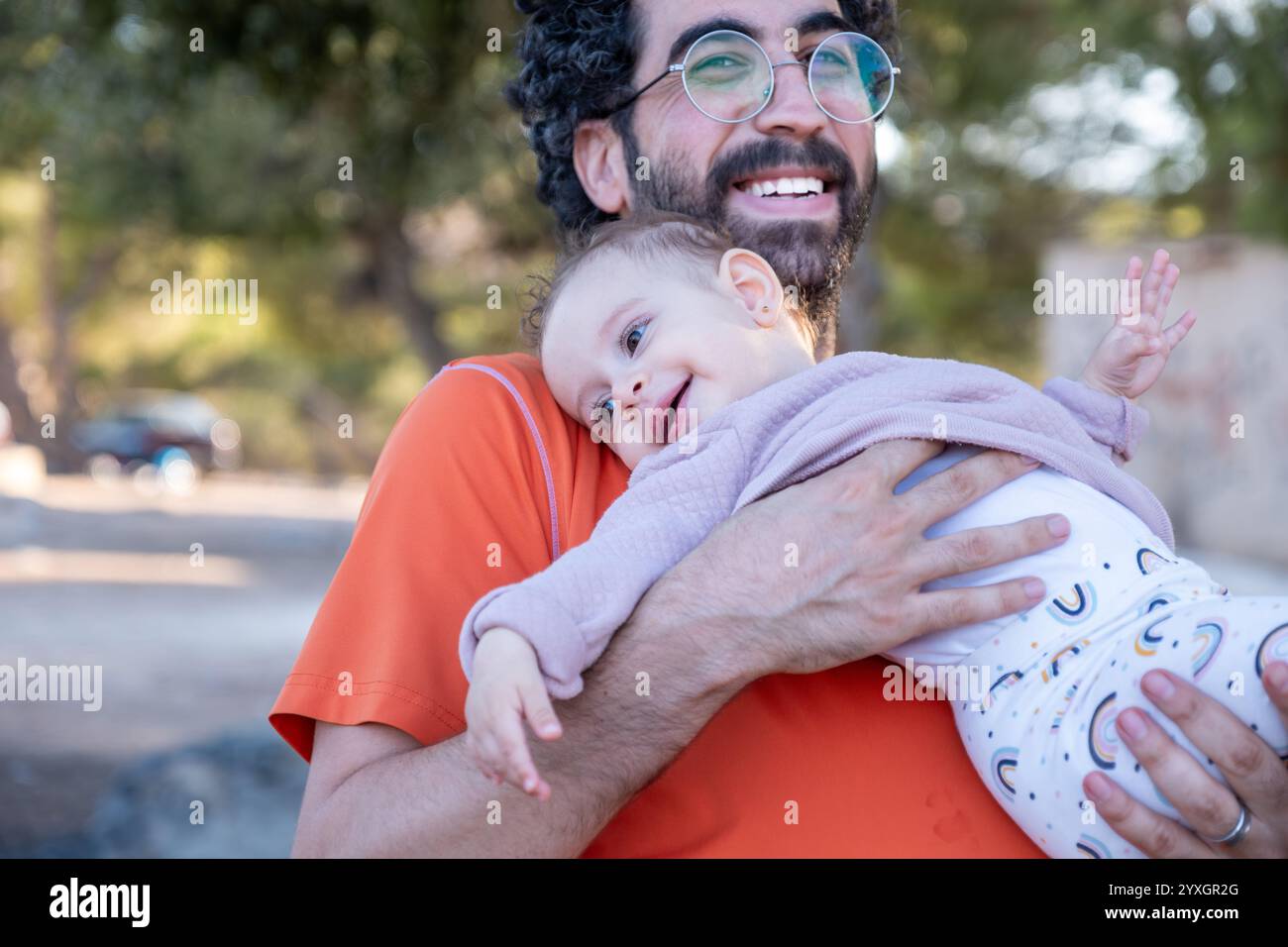 Ein fröhlicher Vater wirft seine kleine Tochter während eines sonnigen Familienausflugs hoch in die Luft und feiert Liebe, Verspieltheit und die kostbare Bindung der Eltern Stockfoto