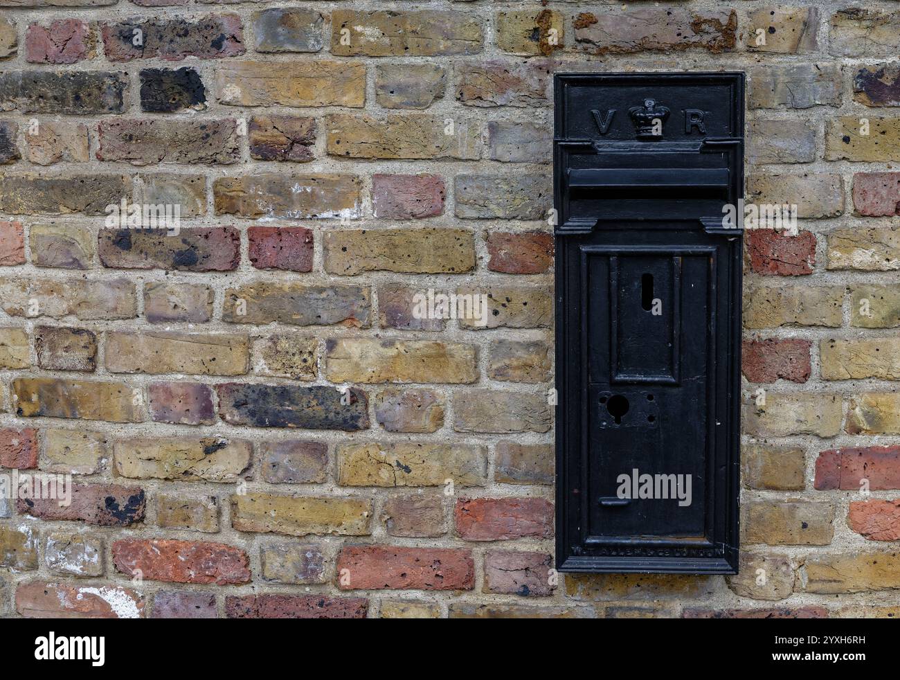 Ein schwarzer Briefkasten an einer Backsteinmauer, The Avenue, Richmond-upon-Thames, London Stockfoto