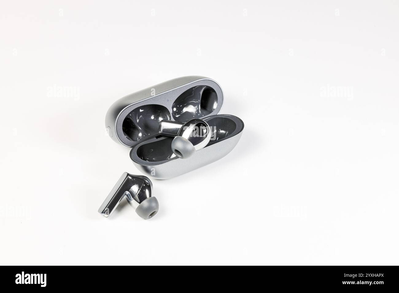 Luxuriöse Bluetooth-Kopfhörer oder -Ohrstöpsel oder Kopfhörer mit Ladetasche auf weißem Hintergrund. Stockfoto