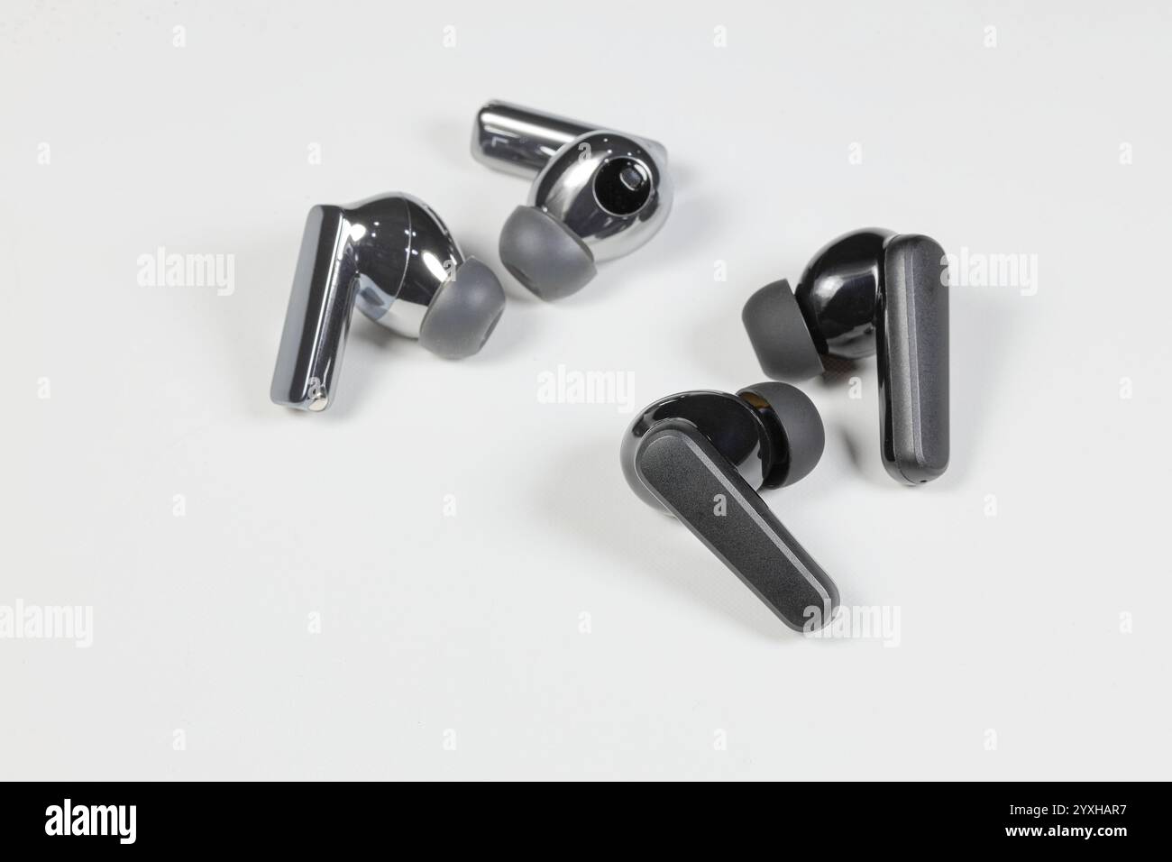 Verschiedene kabellose Bluetooth-Ohrhörer oder -Ohrstöpsel oder -Kopfhörer, isoliert auf weißem Hintergrund. Stockfoto