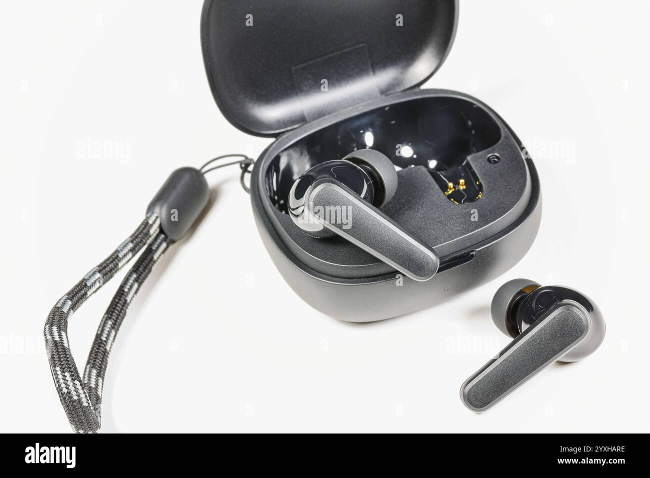 Kabelloser Bluetooth-Ohrhörer oder -Ohrhörer oder Kopfhörer mit Ladetasche auf weißem Hintergrund. Stockfoto