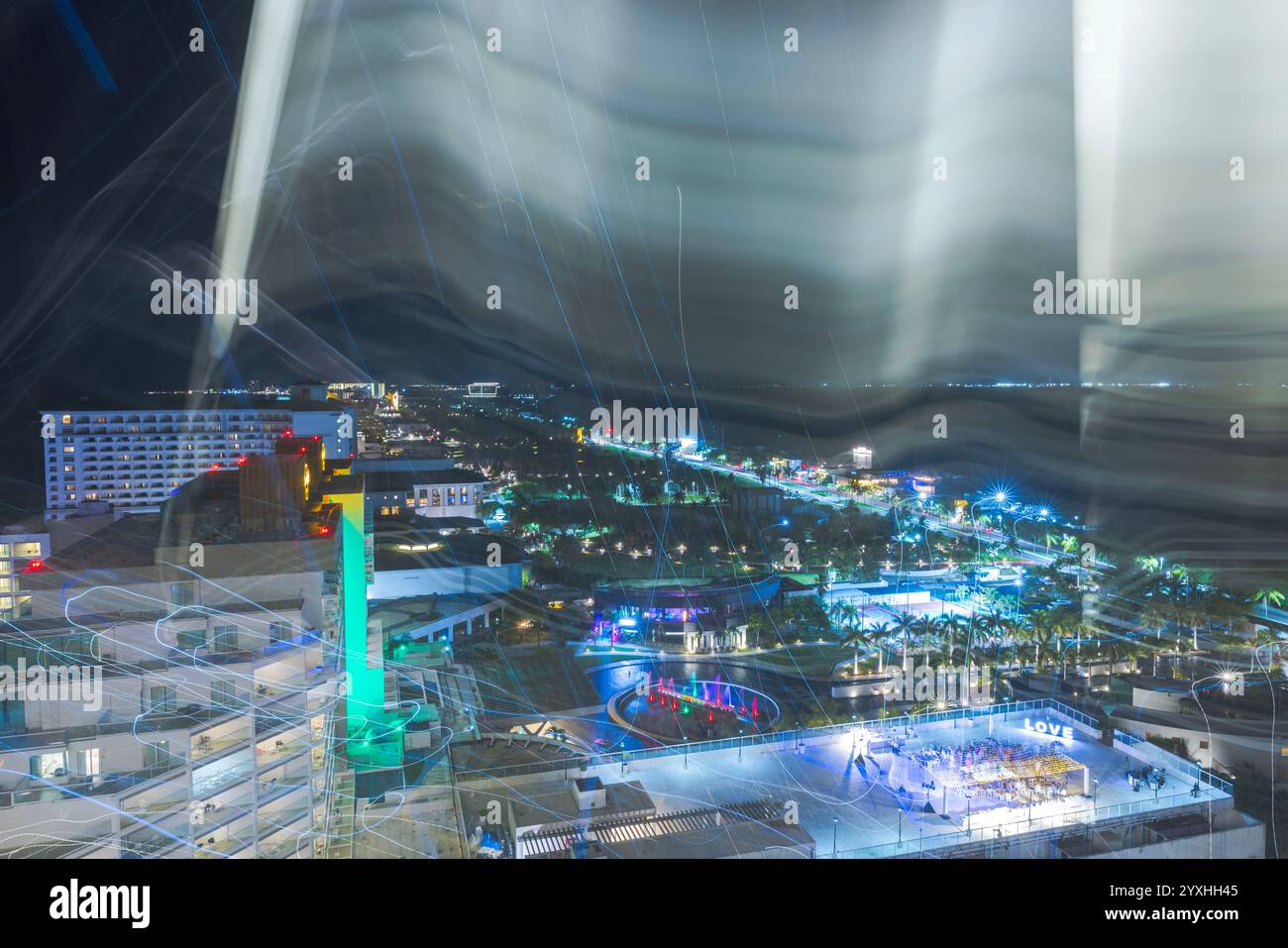 Verschwommenes nächtliches Stadtbild mit bunten Lichtern, Neonreflektionen und Langzeitbelichtungseffekten über der pulsierenden Stadtküste. Cancun. Mexiko. Stockfoto