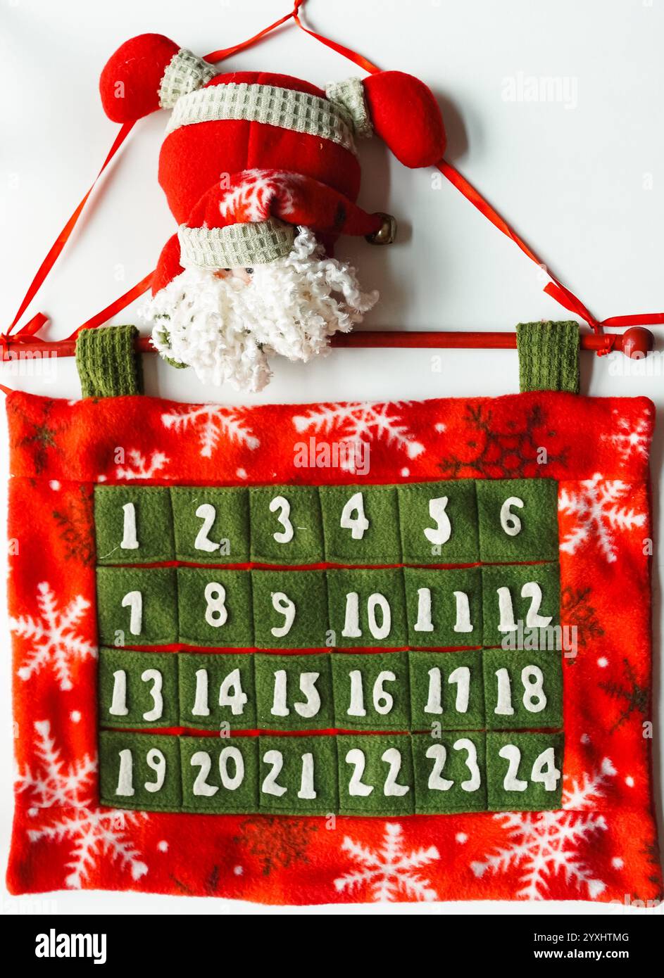 Adventskalender mit Weihnachtsmann aus rotem, grünem und weißem Filzstoff zum Abzählen auf Weihnachten, weißer Hintergrund Stockfoto
